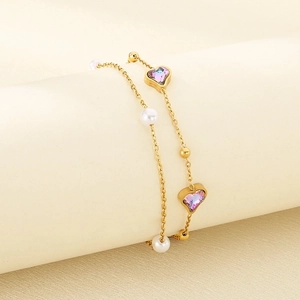 Close-up of golden double-layer anklet with purple heart stones and white pearls