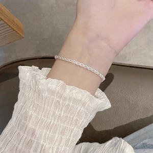 Close-up of elegant S925 sterling silver feather chain bracelet worn on a woman wrist