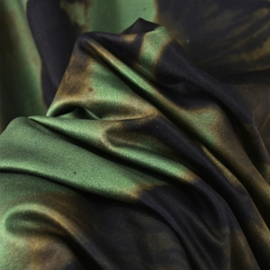 Vue macro d'un tissu stretch camouflage montrant une texture soyeuse et un drapé élégant