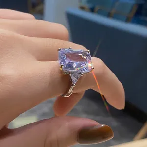Elegant silver ring featuring a large rectangular purple crystal with side triangular stones