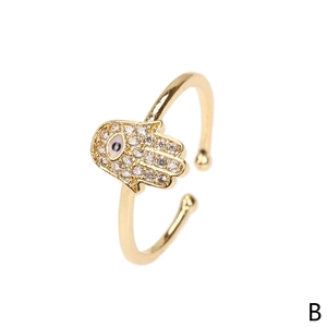 Detailed close-up of golden Hamsa hand ring featuring pave zircon and enamel evil eye