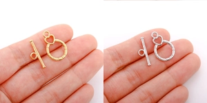 Macro shot of 18k gold and silver heart-shaped OT toggle clasps for DIY jewelry making
