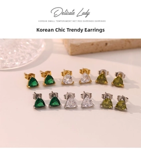 Close-up of triangular zircon stud earrings in emerald green, clear, and olive tones