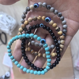 Stack of 6mm natural stone evil eye bracelets in turquoise, obsidian and tiger eye