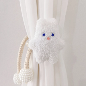 Detail of plush white bear curtain tieback with woven rope and pearl bead fasteners
