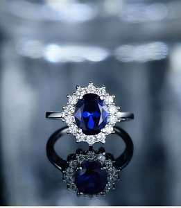 Macro shot of a vintage silver ring with a large oval blue zircon and diamond halo