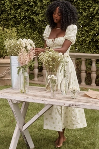 Floral puff sleeve maxi dress with side slit detail worn in a garden garden setting