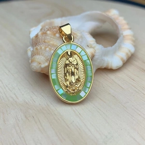 Oval Virgin of Guadalupe pendant with green mosaic inlay on a shell background