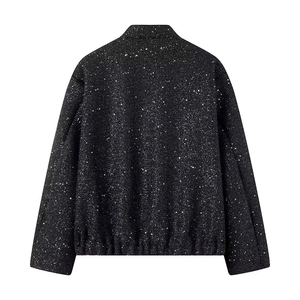 Detail of black sequined jacket back with elastic hem and shimmering fabric texture