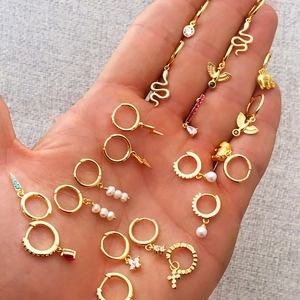 Close-up of S925 gold plated silver earrings with elephant snake and pearl charms