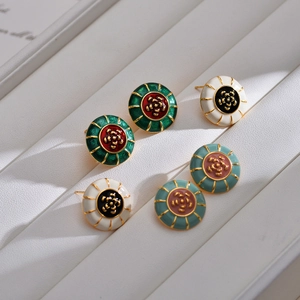 Macro view of vintage style camellia flower earrings with colorful enamel and gold finish