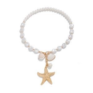 Macro detail of ocean-style necklace with starfish charms and white baroque pearls