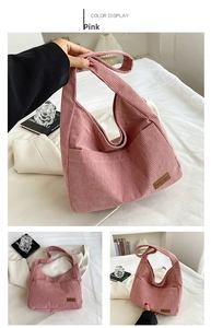 Detailed view of pink corduroy shoulder bag with leather logo patch and wide strap