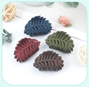 Detailed view of leaf-shaped matte hair claws in navy, red, olive, and brown colors