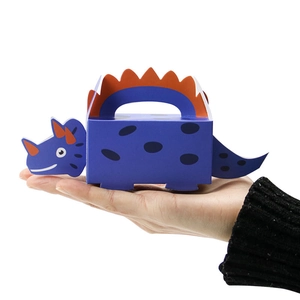 Blue dinosaur paper candy gift box in triceratops shape held by hand on white background