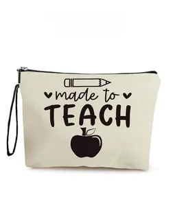 Close-up of cream canvas bag with 'made to TEACH' text, pencil, and apple graphics