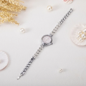 Detailed close-up of a silver luxury bracelet watch with pearl and marquise stone accents