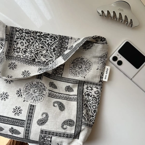 Detailed macro view of retro paisley print and fabric label on cotton linen shoulder bag