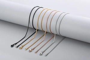 Detail of round snake chain necklaces in black, gold, rose gold and silver stainless steel