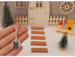 Makroaufnahme einer silbernen Miniatur-Geldschaufel mit russischer Gravur für DIY-Deko