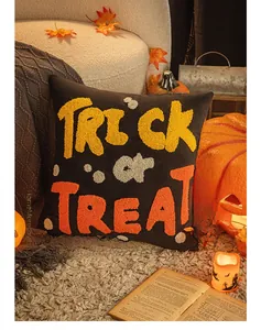 Detailed close-up of Trick or Treat embroidery on a black Halloween decorative pillow