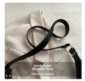 Detail of the black PU leather shoulder strap with golden metal ring and fine stitching