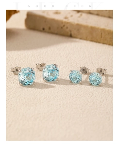 Macro view of two sizes of S925 silver stud earrings with light blue faceted gemstones