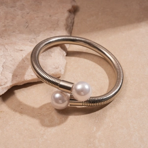 Detailed macro view of silver metallic spring collar with dual white pearl accents