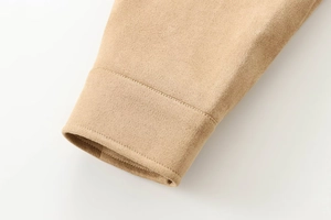 Gros plan du détail du poignet d'une veste en daim kaki avec coutures de haute qualité