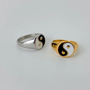 Close-up of stainless steel Yin Yang Tai Chi rings in polished gold and silver finishes