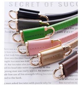 Detail of colorful PU leather straps with golden metal buckles arranged on paper