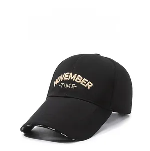 Detailed close-up of khaki 3D letter embroidery and white woven tape on a black baseball cap