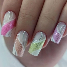 Macro view of French short fake nails with silver metallic swirls and colorful foil patterns