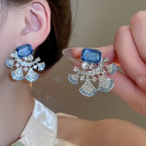 Detailed macro view of luxurious blue floral drop earrings with sparkling rhinestones