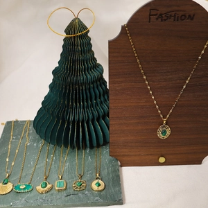 Détail de colliers en or 18 carats avec divers pendentifs en pierre de malachite verte