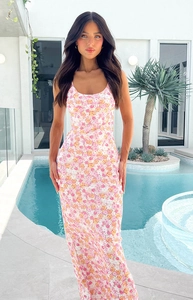 Close-up of pink floral summer dress with thin straps against pool background
