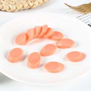 Miniature PVC ham sausage slices displayed on a white plate for dollhouse kitchen play