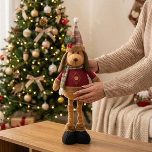 Detail of a plush Christmas dog doll with knitted sweater and hat in warm home setting