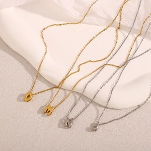 Détail de colliers en acier inoxydable or 18 carats et argent avec lettres O M N J
