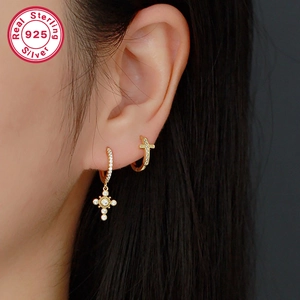 Close-up of gold 925 sterling silver cross hoop earrings with micro-pave cubic zirconia