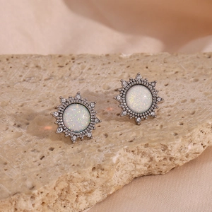 Macro shot of vintage round opal earrings with sparkling crystals on a stone