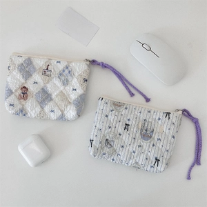 Detailed view of quilted cotton coin pouches with floral patterns and rope zipper pulls