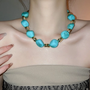Chic acrylic marbled beaded necklace with irregular turquoise and gold beads on a model