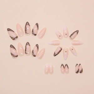 Detail of almond-shaped press-on nails with brown swirl patterns and mini pearls