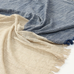 Detail of navy blue and beige linen scarf showing soft fringe and crinkled texture