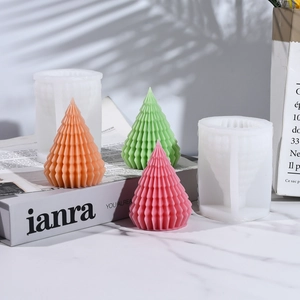 Detail of Christmas tree silicone molds and textured candles on a marble background