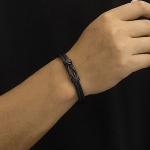 Detailed view of black stainless steel twisted wire cable bracelet with infinity knot design