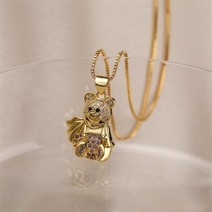 Close-up of gold bear pendant with purple zircon inlay on a delicate box chain necklace