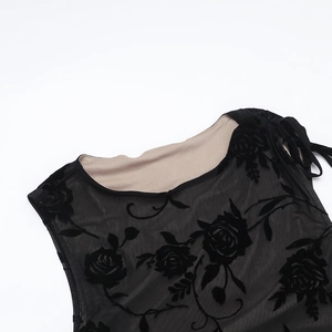 Detailed view of black flocked rose patterns on semi-transparent mesh neckline fabric