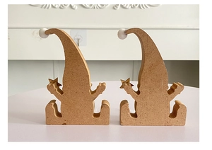 Detailed view of two wooden Christmas gnomes with white pompoms and gold stars